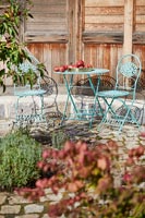 Small blue metal cafe style table and chairs on terrace 