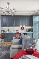 Open plan living space with grey kitchen and red accessories at christmas