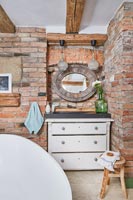 Sink set in old chest of drawers in modern country bathroom 