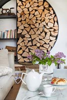 Circular wall mounted shelving and log storage in modern living room  