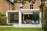 Exterior of modern extension with view into living room through patio doors