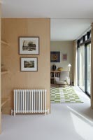 Radiator and pictures on partition wall in open plan living space 