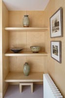 Ceramic bowls and vases on wooden shelving wall 