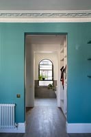 Turquoise painted walls and cornicing over doorway to hallway 