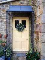 Christmas wreath on front door of country house 