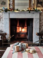 Christmas present and mince pies in front of fireplace