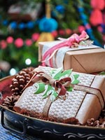 Wrapped Christmas presents on tray with pine cones
