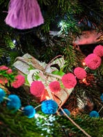 Colourful pompoms as Christmas tree decorations on tree 