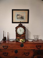 Antique clock on wooden sideboard 