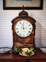 Mince pies next to antique clock on wooden sideboard 