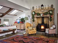 Table laid for Christmas dinner in country dining room with lit fire