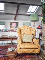 Floral fabric covered armchair in country dining room 