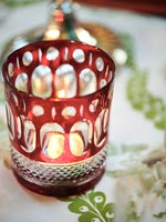 Detail of tealight candle in decorative red glass