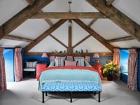 Country bedroom with vaulted ceiling decorated for Christmas 