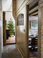 Narrow hallway leading to living room with Christmas tree in country house 