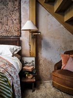 Lamp and Christmas gifts on country bedside table under staircase above 