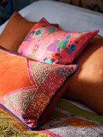 Colourful cushions on bed