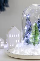 Snow globe with fake trees, fairy lights and cotton wool snow
