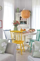 Dining area in small open plan living space decorated in pastel colours 
