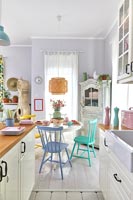 Modern kitchen-diner with pastel accessories in small open plan living space