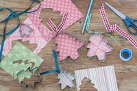 Christmas tree cookie cutters, paper and ribbon for creating decorations