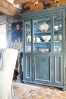 Painted dresser filled with crockery in country living room 