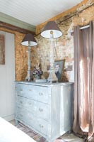 Distressed chest of drawers against stone wall