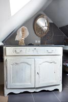 Sideboard with distressed paint in modern bathroom 