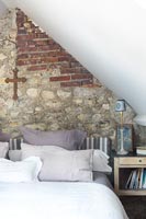 Country bedroom with exposed stone and brick wall 