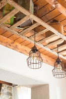 Wooden ladder shelving with exposed beams and metal pendant lights 