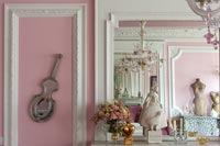 Bright pink eclectic living room with period details and ornaments 