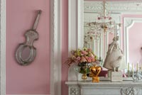 Bright pink eclectic living room with period details and ornaments 