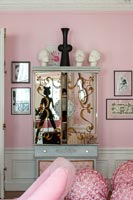 Decorative mirrored cabinet in eclectic pink living room 