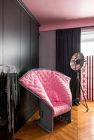 Unusual modern pink upholstered chair in black and pink bedroom 