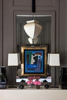 Abstract artwork and lamps next to mirror 