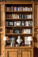 Classic wooden panelled living room with built-in bookshelves 