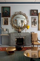 Decorative vintage mirror above fireplace in living room 