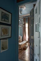 Blue painted classic corridor with view through open door 
