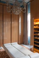 Long Ottoman bench seat and large built-in wardrobes in classic bedroom 