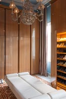 Long Ottoman bench seat and large built-in wardrobes in classic bedroom 
