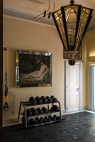 Classic painting and Art Deco light fitting in home gymnasium 