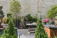 Furniture on decked area of walled courtyard garden 