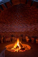 Unusual garden room with lit firepit 