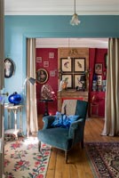 Blue armchair in classic style living room with colourfully painted walls 