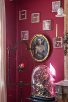 Display of classic paintings and modern artwork on dark red painted wall