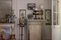 Rustic cabinet surrounded by ornaments and paintings 