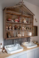 Vintage shelf unit above double sinks in modern country bathroom 