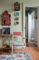 Vintage chair and ornaments next to green painted wall 