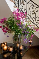 Detail of flower arrangement and tealights on hallway table 