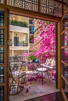 View through doorway to balcony covered in pink blossom flowers 
